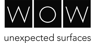 Black and white logo with three squares, each containing a letter to spell WOW. Underneath, the tagline reads unexpected surfaces.