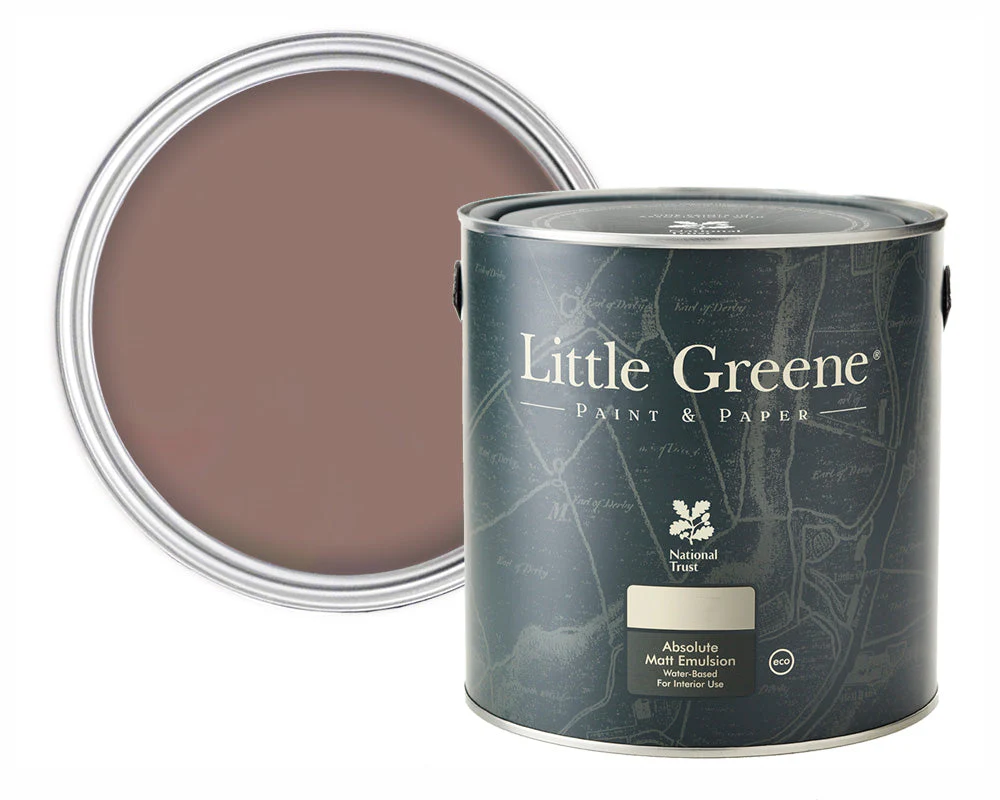 A tin of Little Greene Absolute Matt Emulsion paint sits in front of an open paint tin showing a muted, earthy brown colour. The tin has a dark label with white text and map-like design elements.