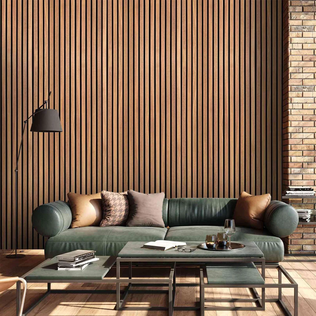 Modern living room with a dark green sofa, brown and beige cushions, black floor lamp, nested coffee tables with books and a glass, set against a timber slat feature wall and exposed brick.