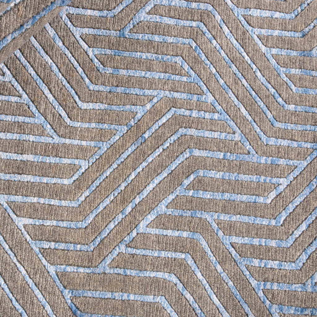 Living Room Rug Ideas. Close-up of a textured carpet or fabric with a geometric pattern of interconnected, angular lines in light blue and beige tones, creating a modern and abstract design.